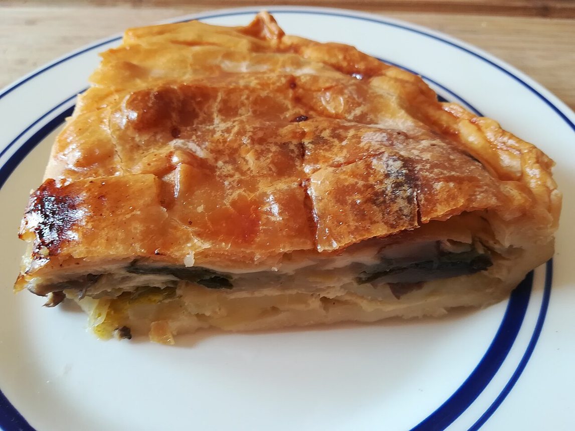 Photographie illustrative : Part de tourte valaisanne dorée, laissant voir sa garniture.