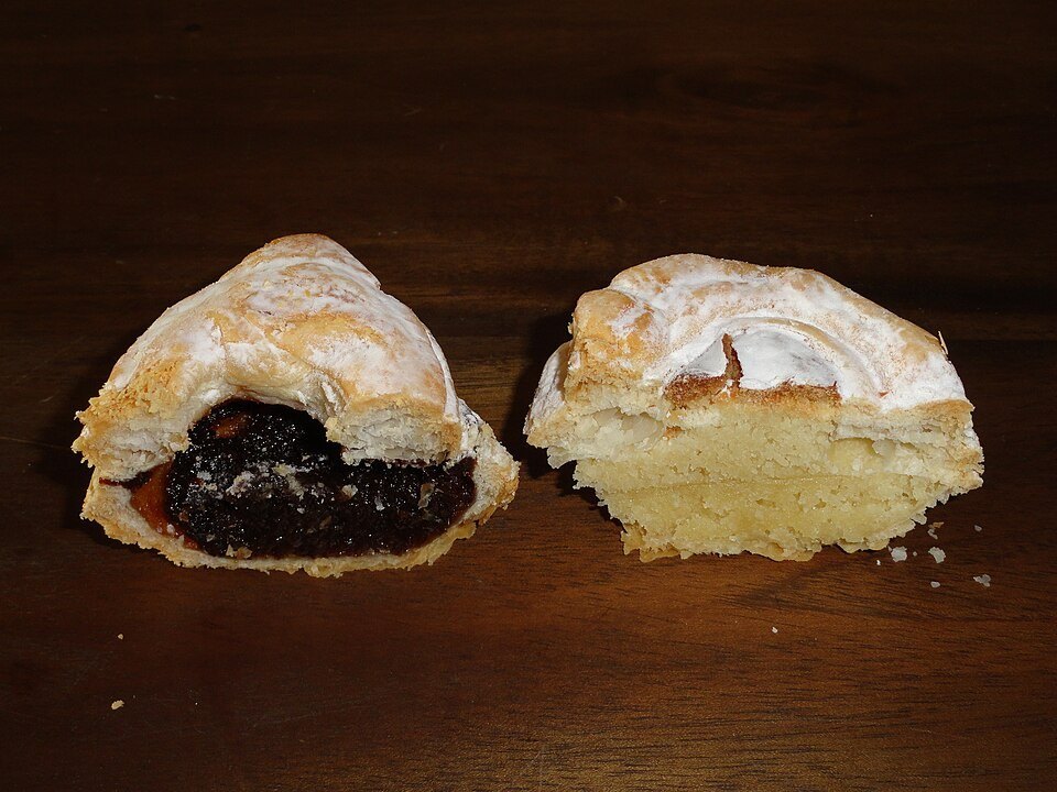Photographie illustrative : Deux pâtisseries glaronnaises individuelles ouvertes, montrant des garnitures aux pruneaux et aux amandes.